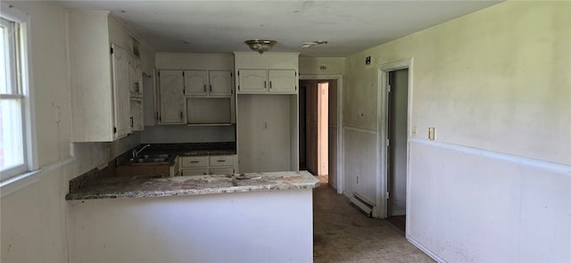 kitchen featuring light tile patterned floors, sink, a wealth of natural light, and kitchen peninsula