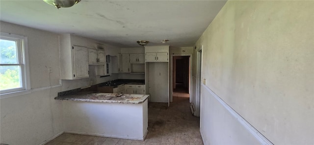 kitchen featuring light tile patterned flooring, sink, and kitchen peninsula