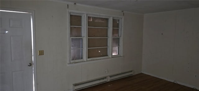 unfurnished room with dark hardwood / wood-style floors and a baseboard heating unit