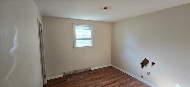 unfurnished room with dark wood-type flooring