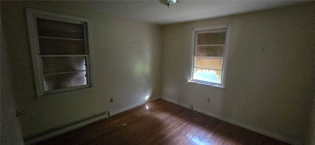 empty room with hardwood / wood-style flooring and a baseboard radiator