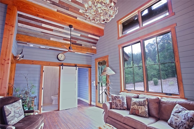 unfurnished sunroom with a notable chandelier, a barn door, and beam ceiling