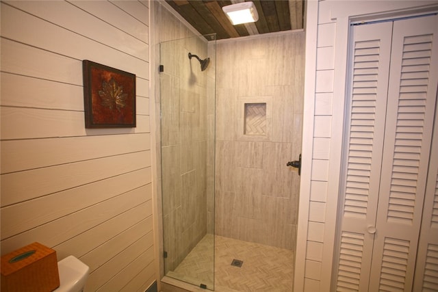 bathroom featuring a shower with shower door and toilet