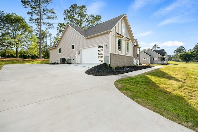 view of home's exterior featuring a garage, central AC unit, and a lawn