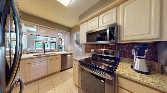 kitchen featuring decorative backsplash, appliances with stainless steel finishes, light stone counters, and light tile patterned floors