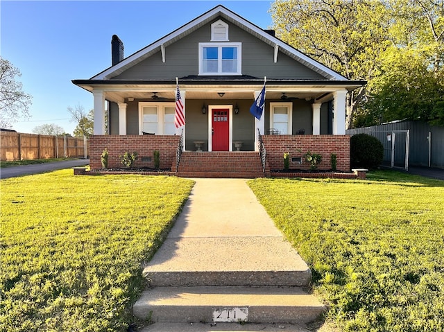 bungalow featuring covered porch and a front lawn