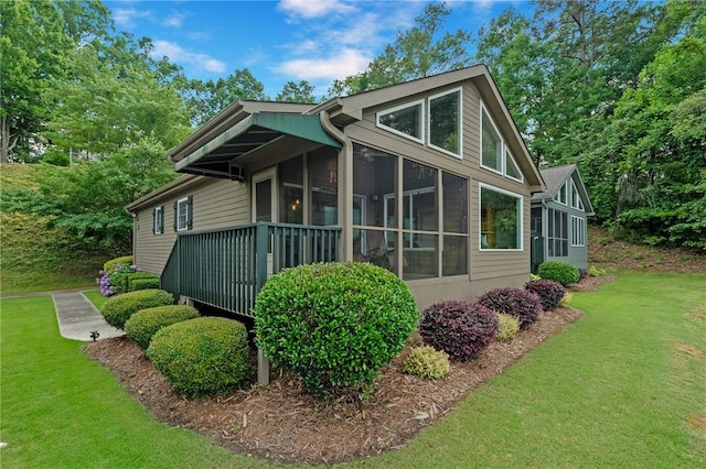 view of property exterior with a sunroom and a lawn