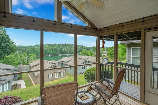 sunroom / solarium featuring a water view, ceiling fan, and vaulted ceiling