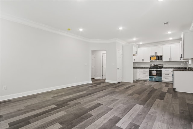 kitchen with white cabinetry, dark hardwood / wood-style floors, crown molding, and appliances with stainless steel finishes