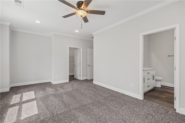 unfurnished bedroom featuring dark colored carpet, ensuite bath, and ornamental molding