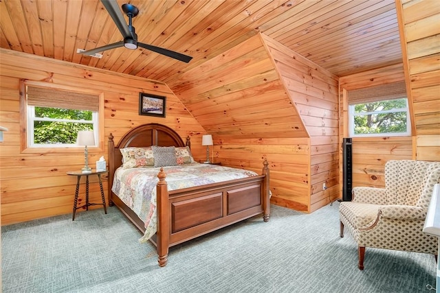 bedroom with multiple windows, carpet floors, wood ceiling, and wooden walls