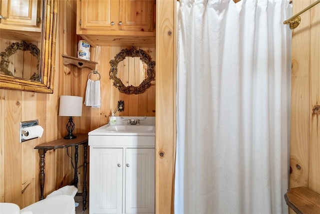 bathroom featuring vanity and wood walls