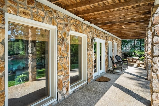 unfurnished sunroom with beam ceiling and wood ceiling