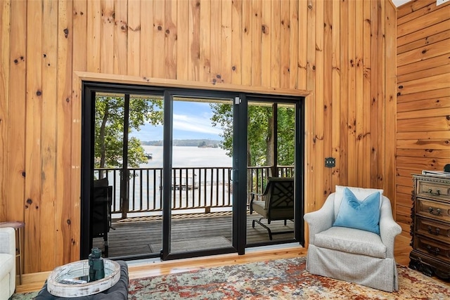 entryway featuring hardwood / wood-style flooring, a water view, and wooden walls