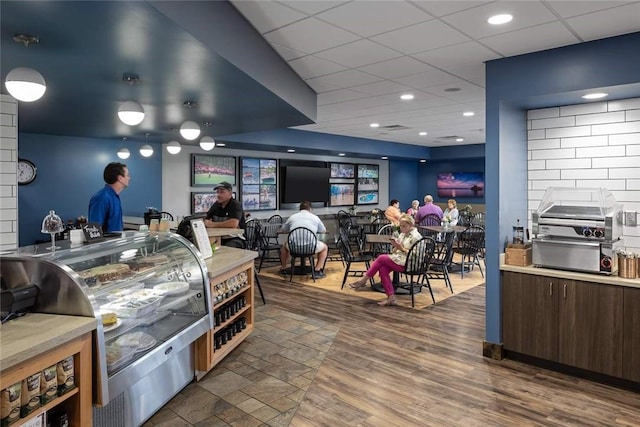 interior space featuring a drop ceiling and dark wood-type flooring