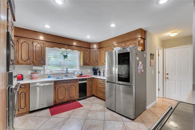 kitchen with light tile patterned flooring, stainless steel appliances, and sink