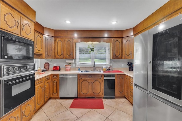 kitchen featuring light tile patterned floors, sink, and black appliances