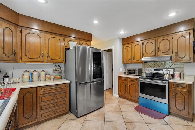 kitchen featuring decorative backsplash, light tile patterned floors, and appliances with stainless steel finishes