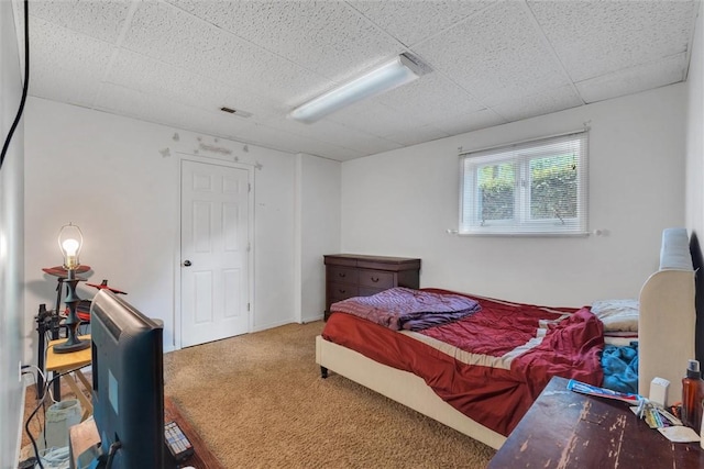 bedroom with carpet and a paneled ceiling