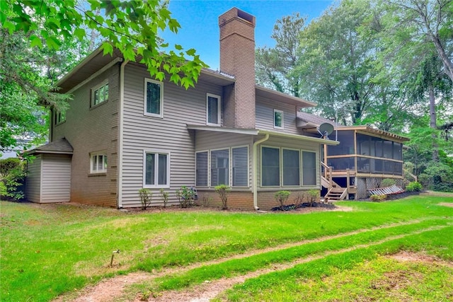 back of house featuring a lawn and a sunroom