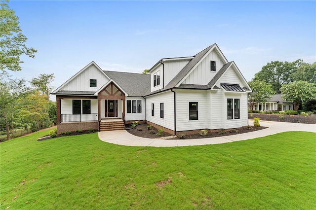 modern farmhouse with covered porch and a front lawn