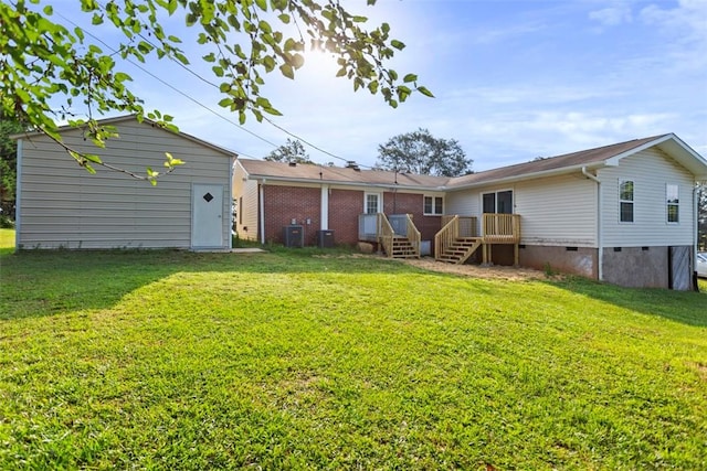 back of property featuring central air condition unit and a lawn