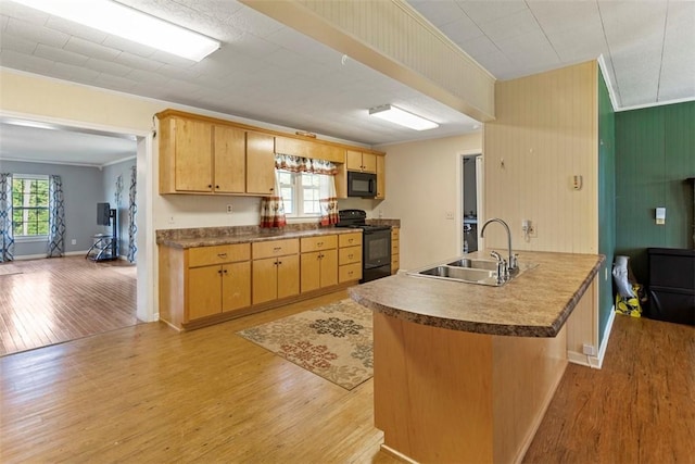 kitchen featuring sink, ornamental molding, kitchen peninsula, black appliances, and light wood-type flooring