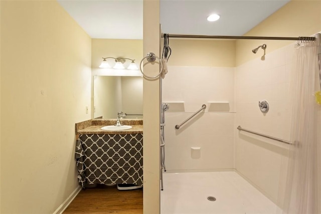 bathroom with walk in shower, vanity, and hardwood / wood-style flooring