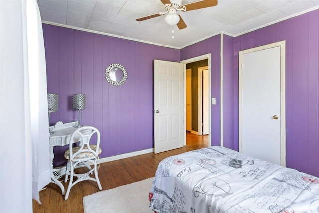 bedroom featuring hardwood / wood-style floors, ceiling fan, and crown molding