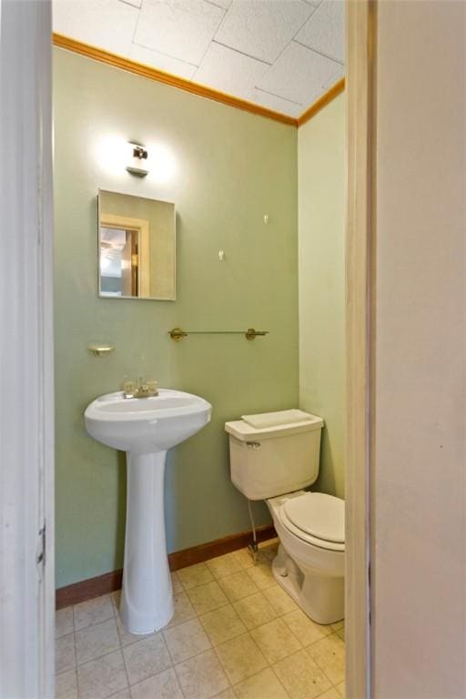 bathroom featuring crown molding and toilet