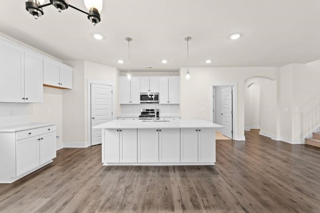 kitchen featuring decorative light fixtures, white cabinets, and hardwood / wood-style floors