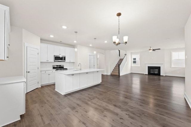 kitchen with decorative light fixtures, stove, white cabinets, and dark hardwood / wood-style floors