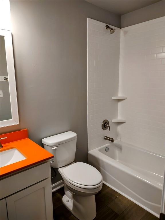 full bathroom featuring vanity, wood-type flooring, shower / washtub combination, and toilet