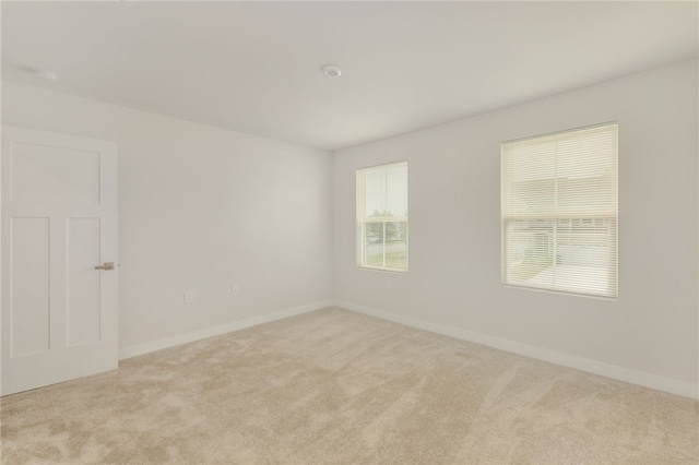 unfurnished room featuring light carpet and a healthy amount of sunlight