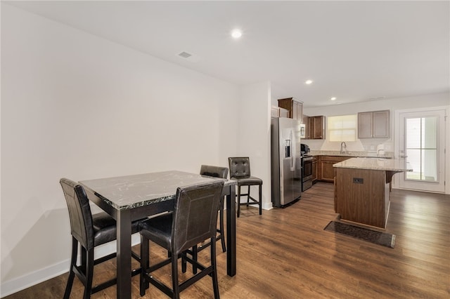 dining room featuring sink and dark hardwood / wood-style flooring