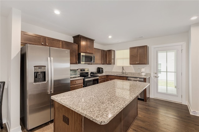 kitchen featuring sink, appliances with stainless steel finishes, dark wood-type flooring, and a kitchen island