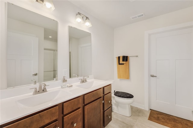 bathroom with vanity, a shower with shower door, toilet, and tile patterned flooring