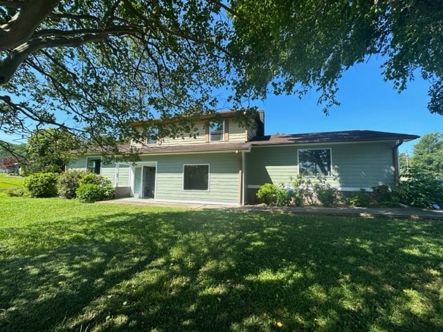 back of house with a lawn