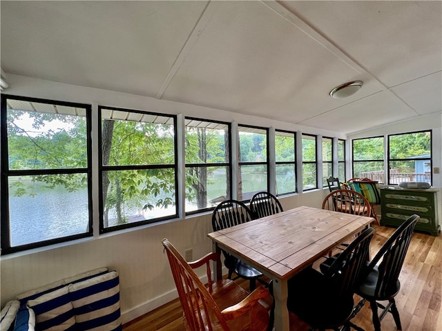 dining space featuring a wealth of natural light, a water view, and wood-type flooring