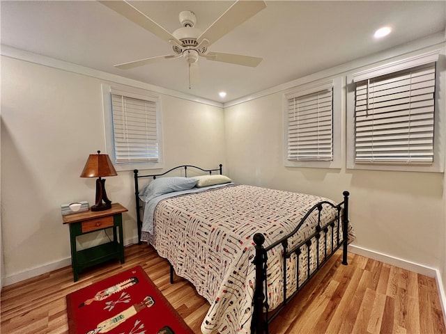 bedroom with ornamental molding, wood-type flooring, and ceiling fan