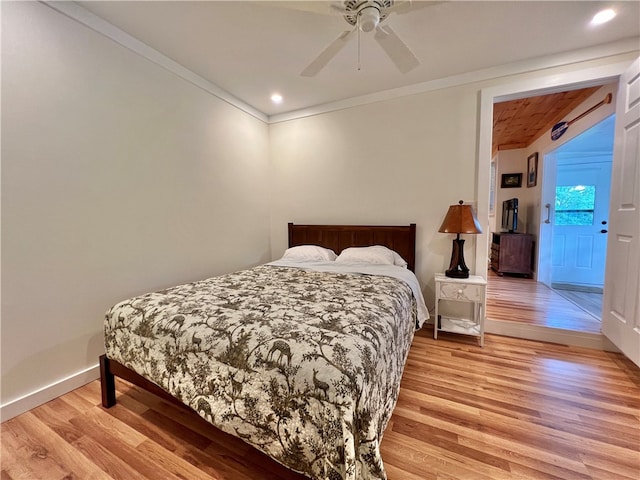 bedroom featuring light wood-type flooring, ceiling fan, and crown molding