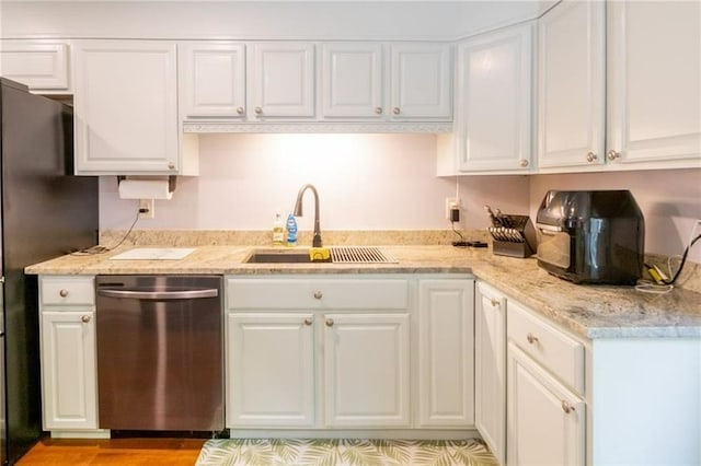 kitchen featuring refrigerator, dishwasher, sink, and white cabinets