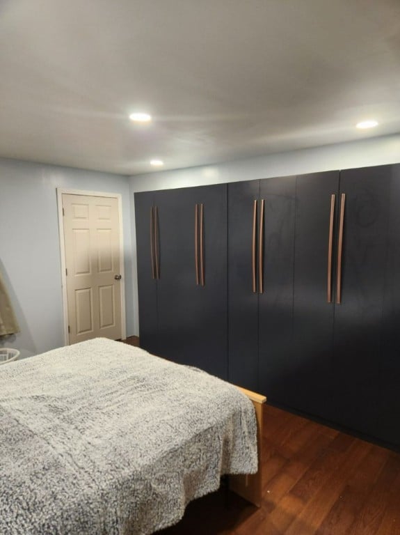 bedroom with dark hardwood / wood-style floors