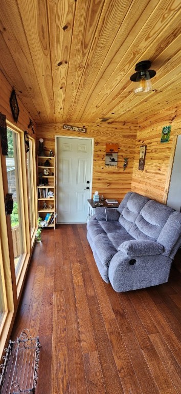 living area featuring wood-type flooring, wood walls, and wooden ceiling