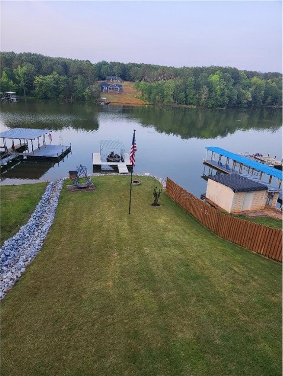 dock area with a lawn and a water view