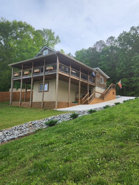 back of property featuring a deck and a yard