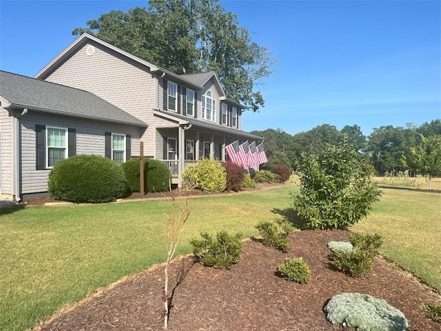 view of side of home with a lawn and covered porch