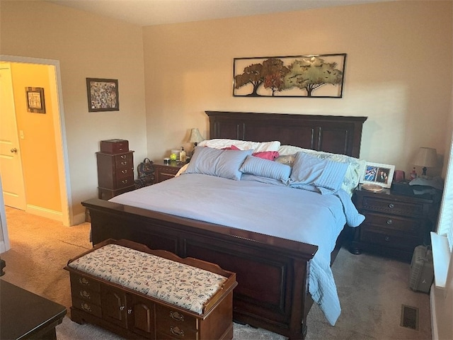 bedroom featuring baseboards, light carpet, and visible vents