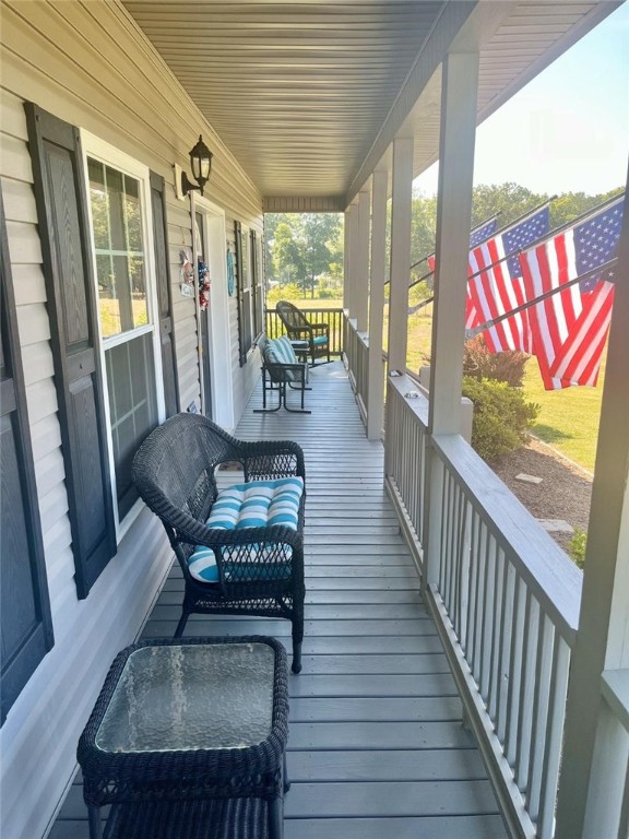 wooden deck featuring a porch and fence