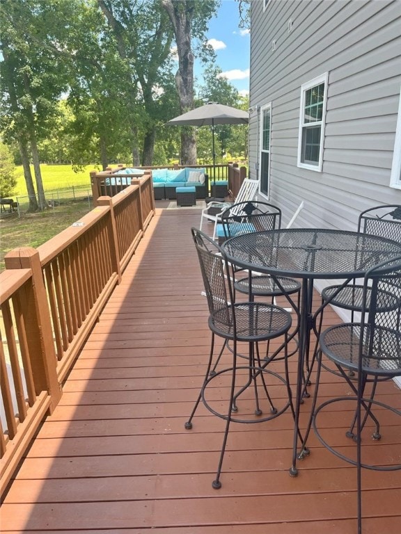 wooden deck featuring fence, outdoor dining area, and an outdoor hangout area